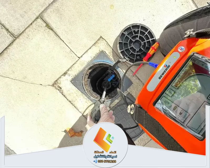 شركة كشف تسربات المياه بالرياض 0578673748 اتحاد المملكة رجل يقوم بإصلاح مجرى صرف المياه باستخدام أداة.