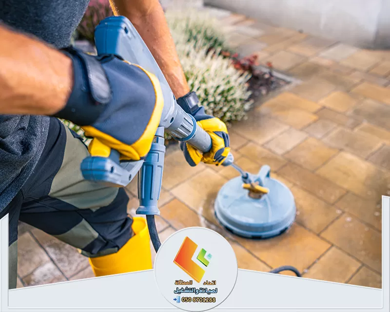 جلي بلاط بالرياض | 0578673748 | شركة اتحاد المملكة يقوم رجل بتشغيل غسالة ضغط لتنظيف سطح الفناء، مما يؤدي إلى إزالة الأوساخ والغبار بشكل فعال.