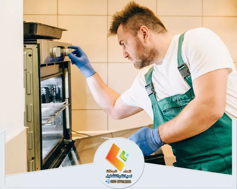 فني تصليح وصيانة افران الغاز بالرياض 0578673748 اتحاد المملكة فني تصليح يرتدي مئزر ويعمل على إصلاح فرن كهربائي بالرياض