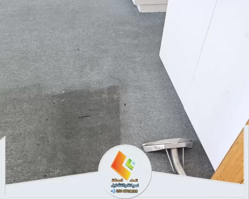تنظيف موكيت رمادي وإزالة البقع والأوساخ المتراكمة باستخدام معدات تنظيف السجاد الاحترافية.